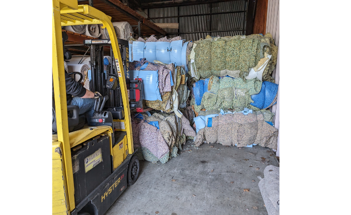 Warehouse crew baling carpet padding to recycle